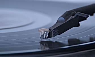 Close-up of a turntable stylus resting on a black vinyl record